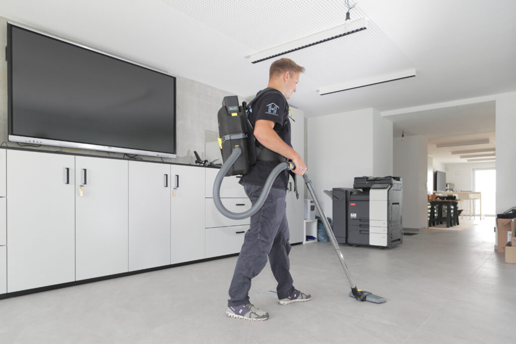 Hausmeisterservice Julian Hansen aus Bönnigheim bei der professionellen Gebäudereinigung in einem modernen Büro mit Rucksackstaubsauger – Gebäudereinigung und Unterhaltsreinigung für gewerbliche Objekte im Landkreis Ludwigsburg und der Region Heilbronn-Stuttgart.